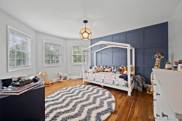 bedroom with dark hardwood / wood-style flooring and multiple windows