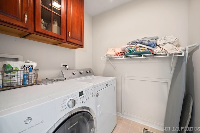 laundry room featuring washing machine and clothes dryer and cabinets