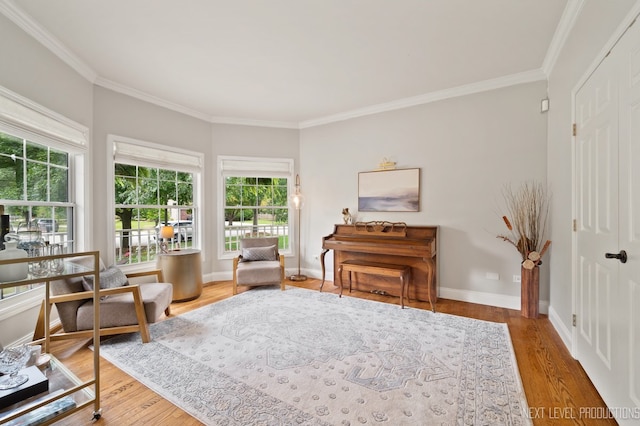 living area with hardwood / wood-style floors and ornamental molding