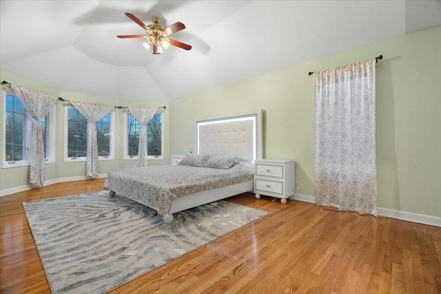 bedroom with light hardwood / wood-style floors, vaulted ceiling, and ceiling fan