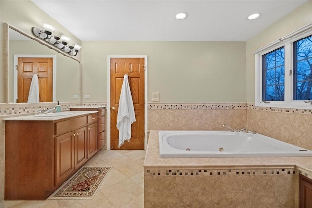 bathroom featuring tile patterned flooring, vanity, a relaxing tiled tub, and tile walls