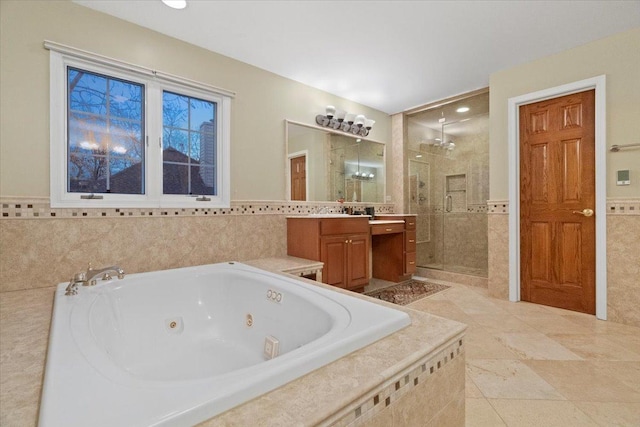 bathroom with plus walk in shower, vanity, tile walls, and tile patterned flooring