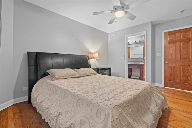 bedroom with hardwood / wood-style flooring, ceiling fan, and ensuite bath