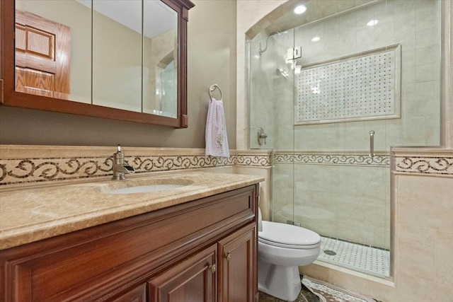 bathroom featuring vanity, toilet, tile walls, and walk in shower