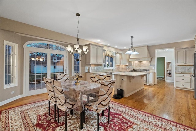 dining space featuring light hardwood / wood-style floors and a notable chandelier