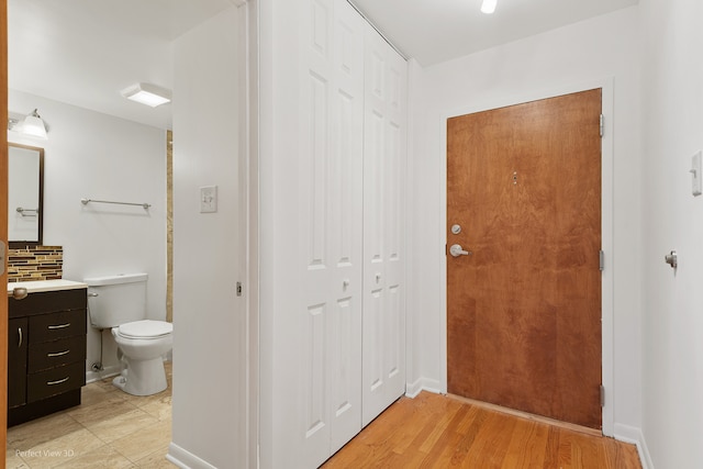 interior space with hardwood / wood-style floors, vanity, and toilet