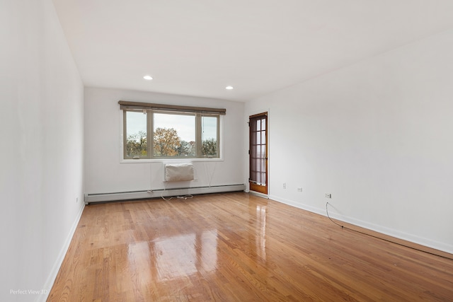 spare room featuring light hardwood / wood-style flooring and a baseboard heating unit