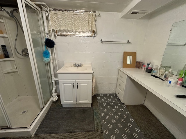 bathroom with a shower with door and vanity