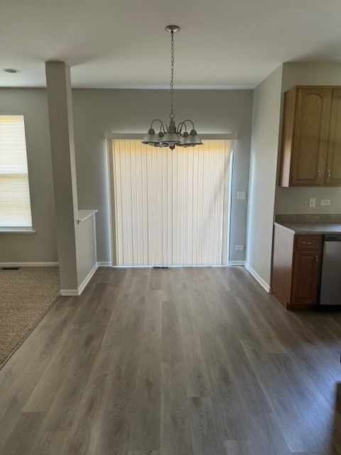 unfurnished dining area with dark hardwood / wood-style flooring and a chandelier