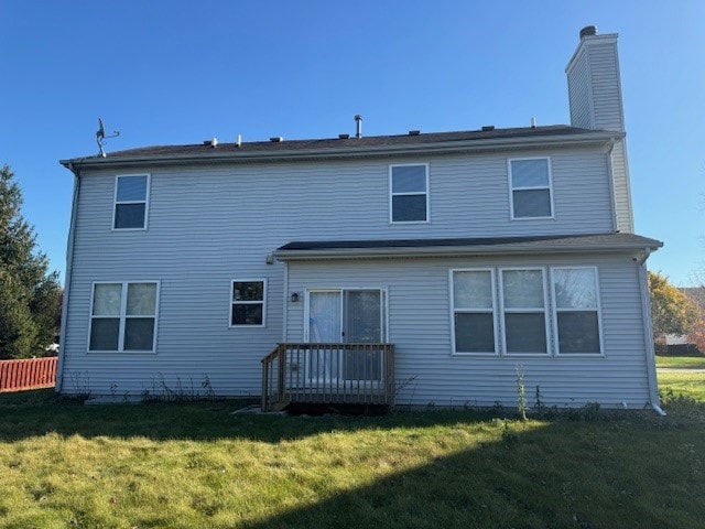 rear view of property featuring a yard and a deck