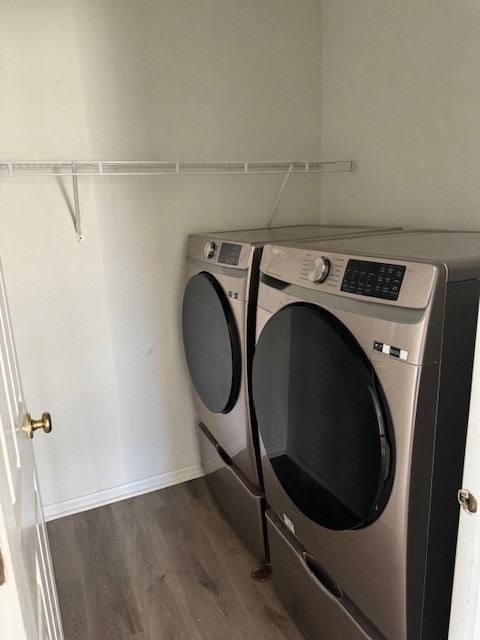 laundry area with dark hardwood / wood-style flooring and washing machine and clothes dryer