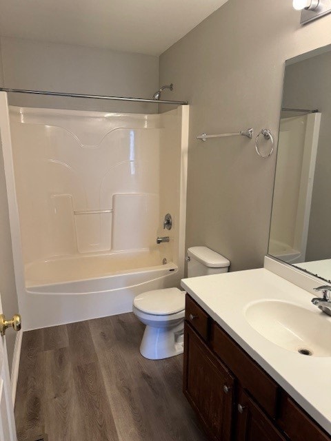 full bathroom featuring washtub / shower combination, hardwood / wood-style flooring, toilet, and vanity