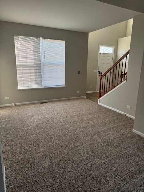 unfurnished room featuring dark carpet