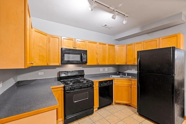 kitchen featuring light tile patterned floors, sink, track lighting, and black appliances