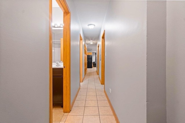 corridor with light tile patterned floors and sink