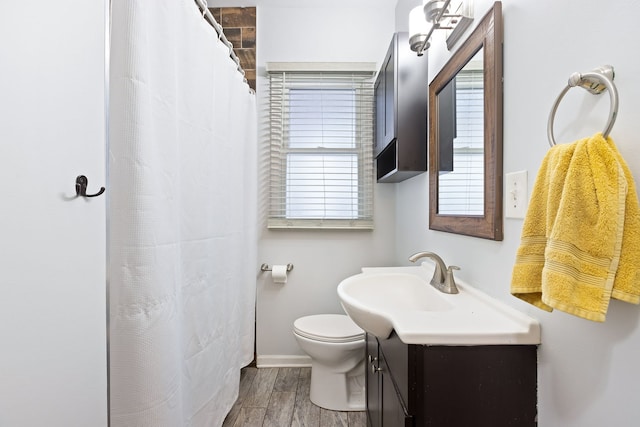 bathroom with vanity, toilet, and hardwood / wood-style flooring