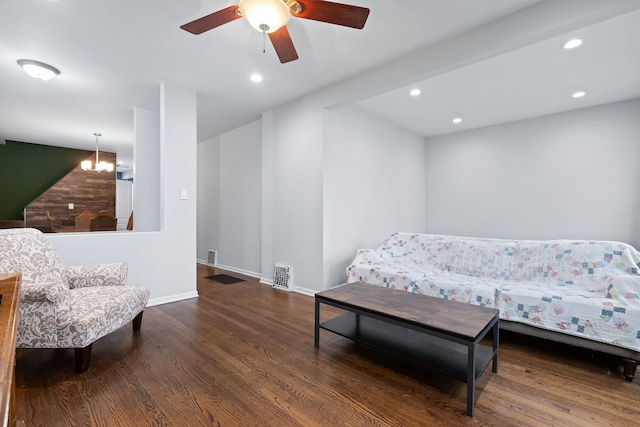 bedroom featuring ceiling fan with notable chandelier and dark hardwood / wood-style floors