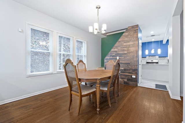 dining area featuring dark wood-type flooring and a notable chandelier