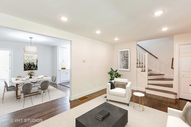 living room with a notable chandelier and dark hardwood / wood-style flooring