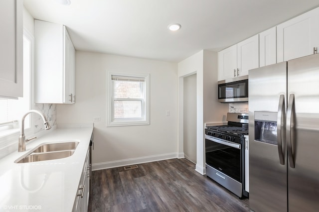 kitchen with dark hardwood / wood-style flooring, sink, white cabinetry, and stainless steel appliances