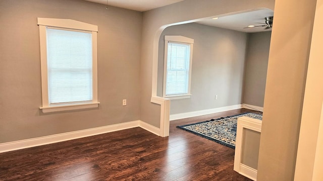 unfurnished room with ceiling fan and dark hardwood / wood-style flooring