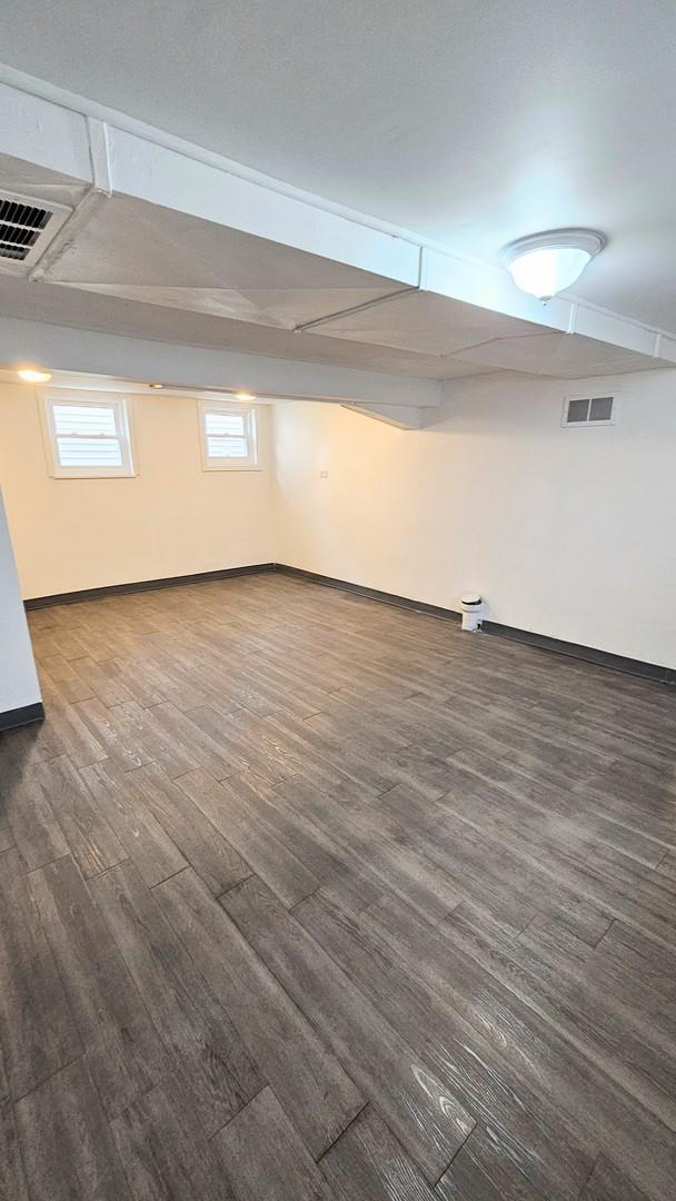 basement with dark hardwood / wood-style floors