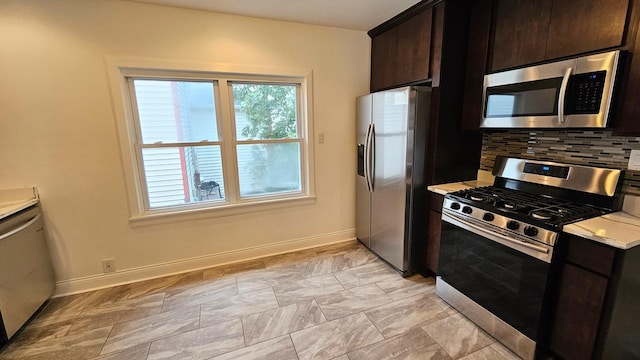 kitchen featuring appliances with stainless steel finishes, dark brown cabinetry, and backsplash