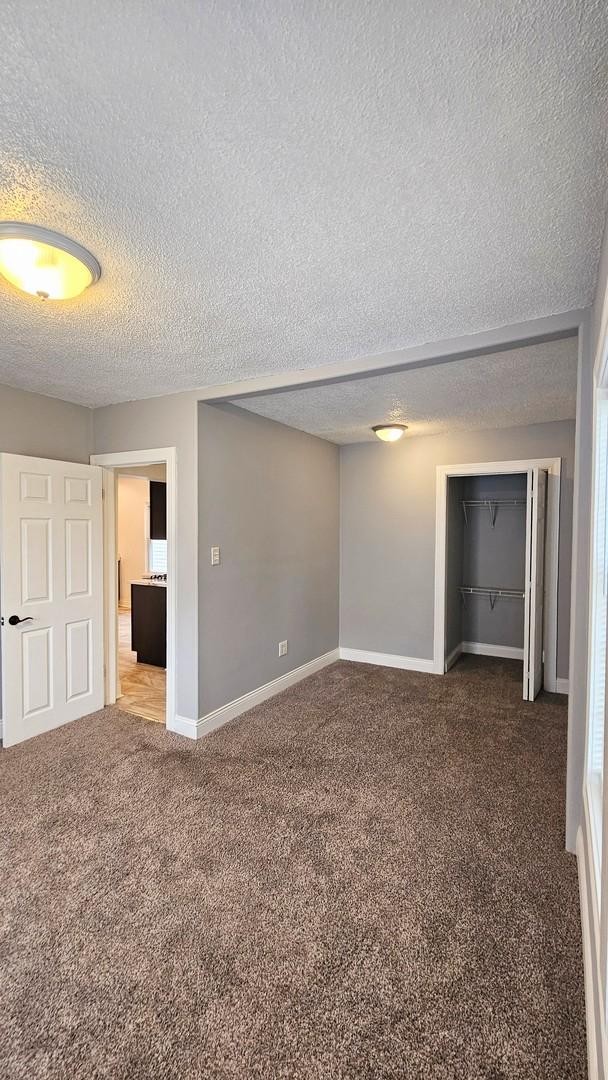 carpeted spare room featuring a textured ceiling