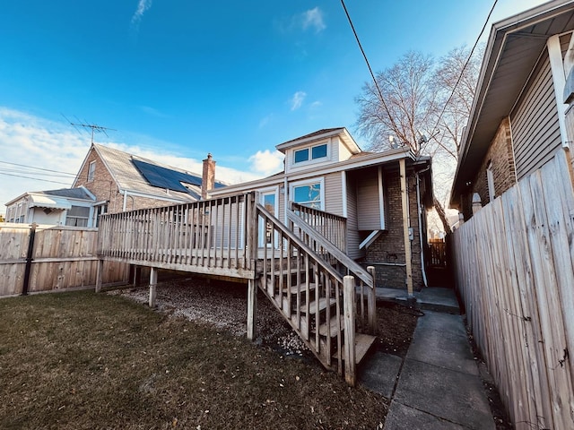 rear view of house featuring a yard and a deck