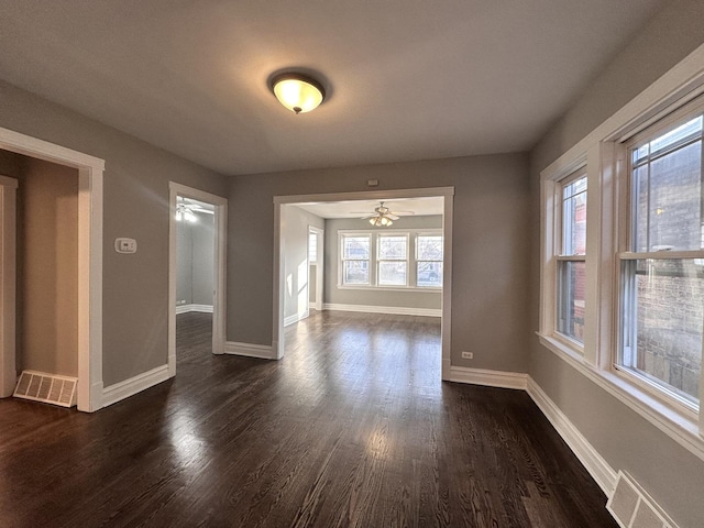 empty room with dark hardwood / wood-style floors and ceiling fan