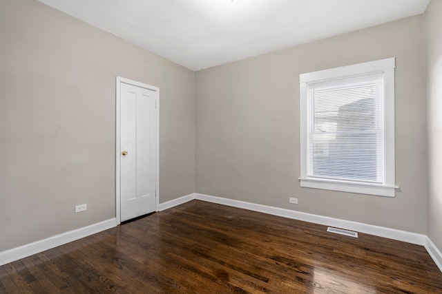 unfurnished room featuring dark wood-type flooring