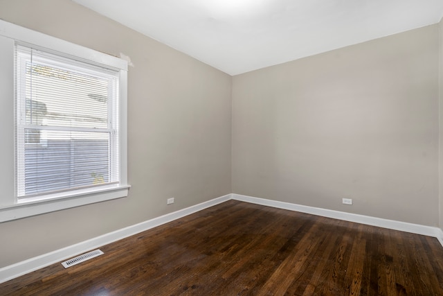 empty room with dark hardwood / wood-style flooring