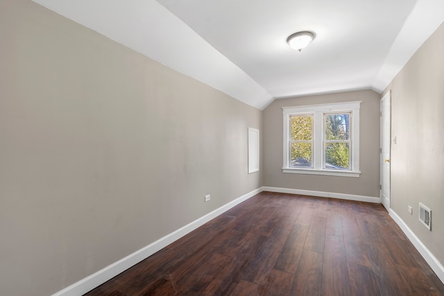 unfurnished room with dark hardwood / wood-style flooring and vaulted ceiling