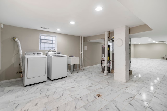 laundry area featuring sink, gas water heater, and washer and dryer