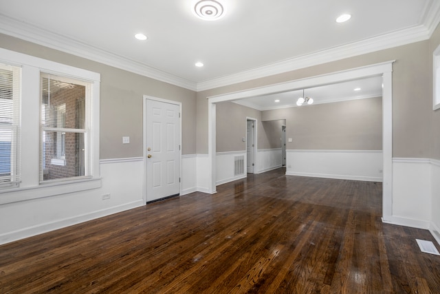 unfurnished living room with a notable chandelier, dark wood-type flooring, and crown molding