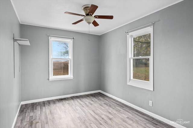 unfurnished room with plenty of natural light, ornamental molding, and light hardwood / wood-style flooring