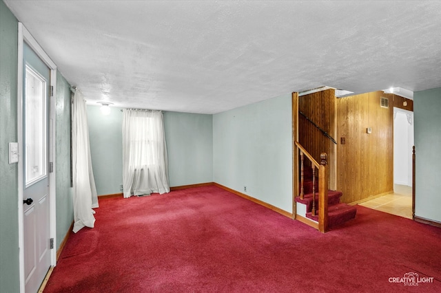 spare room with a textured ceiling and carpet floors