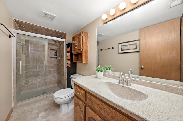 bathroom with tile patterned flooring, vanity, toilet, and walk in shower