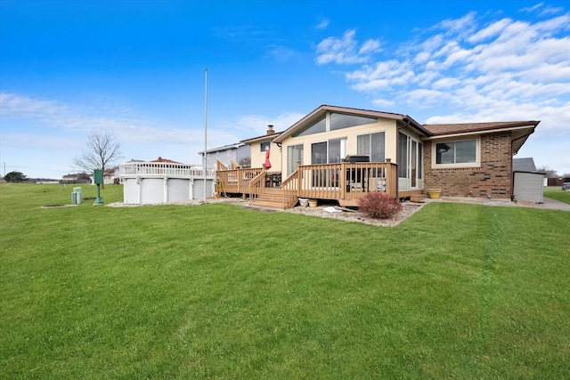 back of property featuring a swimming pool side deck and a lawn