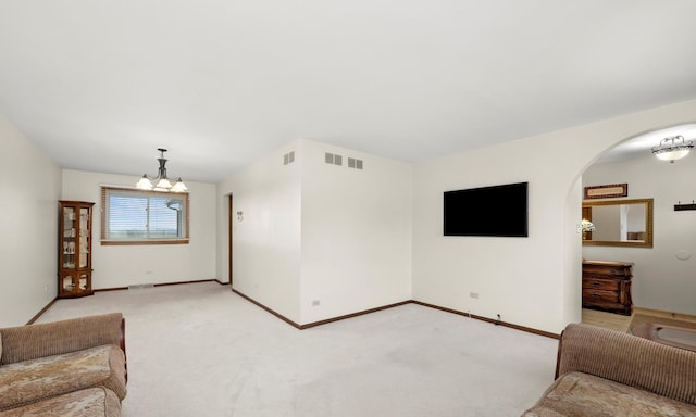 living room with light carpet and a notable chandelier