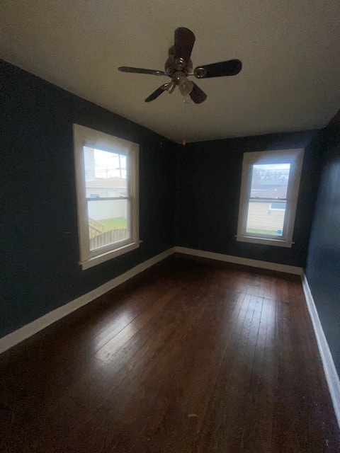 unfurnished room featuring ceiling fan, plenty of natural light, and dark hardwood / wood-style floors