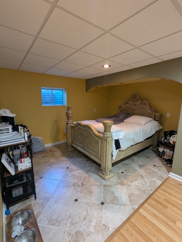 bedroom featuring light hardwood / wood-style flooring and a paneled ceiling