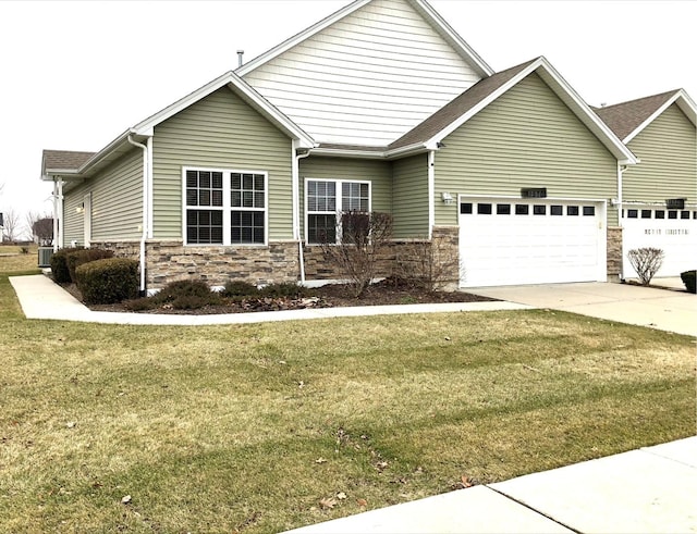 craftsman-style house with a front lawn, a garage, central AC unit, stone siding, and concrete driveway