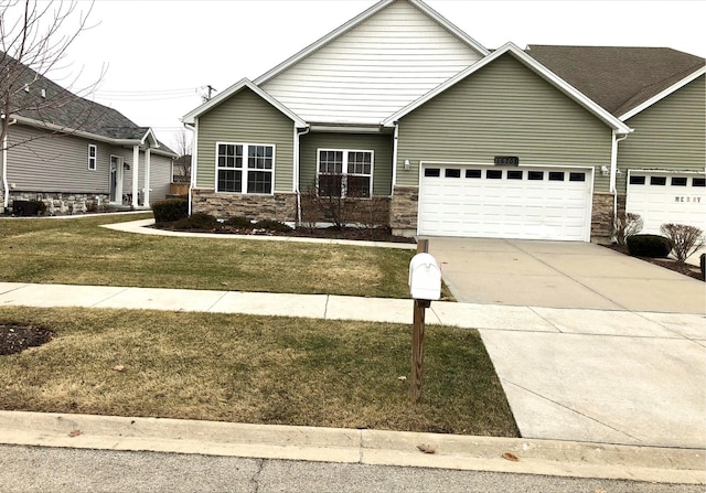 craftsman-style house with a garage, concrete driveway, a front yard, and stone siding