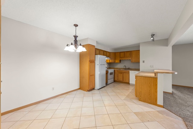 kitchen featuring white appliances, decorative light fixtures, a kitchen bar, an inviting chandelier, and sink