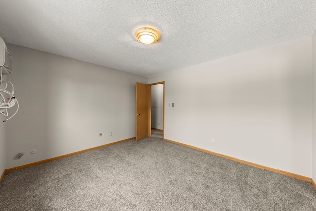 carpeted spare room with a textured ceiling