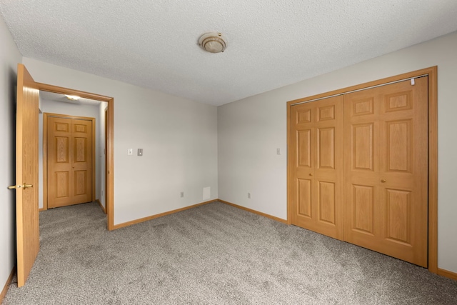 unfurnished bedroom featuring a closet, light carpet, and a textured ceiling