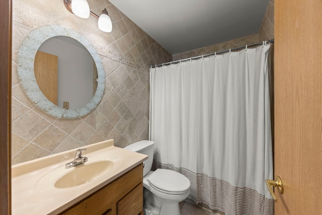 bathroom featuring toilet, walk in shower, tile walls, and vanity