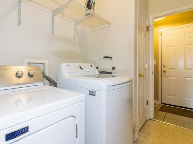 laundry area featuring light tile patterned floors and separate washer and dryer