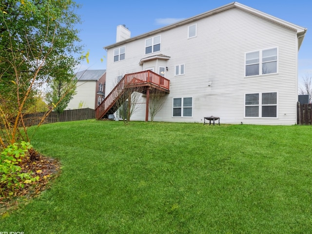 back of house featuring a wooden deck and a yard